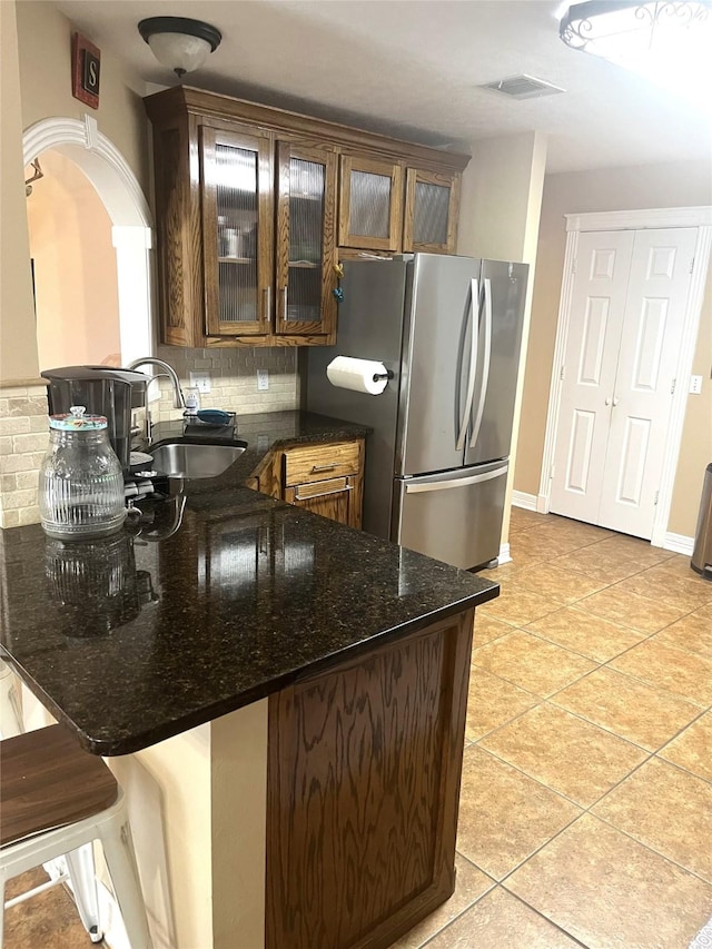 202 Golfview Dr, Normangee, TX 77871 - kitchen featuring a sink, freestanding refrigerator, decorative backsplash, a peninsula, and light tile patterned floors