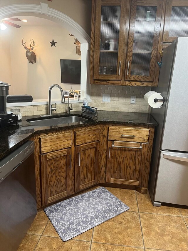 202 Golfview Dr, Normangee, TX 77871 - kitchen with stainless steel appliances, a sink, light tile patterned floors, glass insert cabinets, and dark stone counters