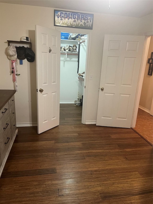 202 Golfview Dr, Normangee, TX 77871 - unfurnished bedroom featuring dark wood-style floors, baseboards, a closet, and a spacious closet