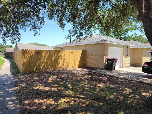 3534 Churchill Gardens Ln, Houston, TX 77066 - view of side of property with an attached garage, fence, brick siding, driveway, and a shingled roof
