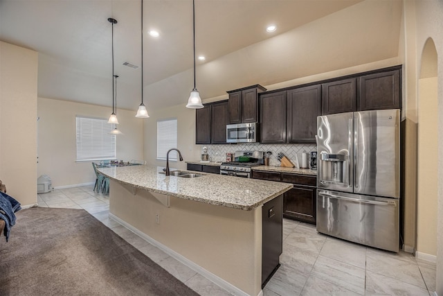 214 San Bernard Dr, Baytown, TX 77523 - kitchen with appliances with stainless steel finishes, a sink, dark brown cabinets, decorative backsplash, and an island with sink
