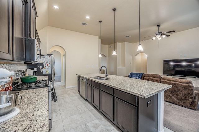 214 San Bernard Dr, Baytown, TX 77523 - kitchen featuring a sink, arched walkways, appliances with stainless steel finishes, ceiling fan, and a kitchen island with sink