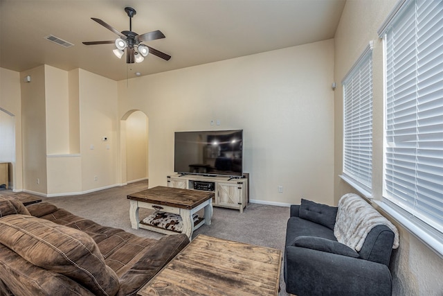 214 San Bernard Dr, Baytown, TX 77523 - carpeted living room featuring arched walkways, a ceiling fan, baseboards, and plenty of natural light