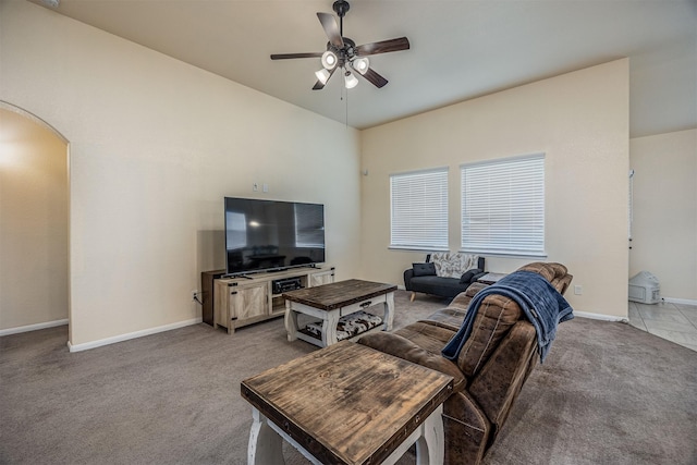 214 San Bernard Dr, Baytown, TX 77523 - living room featuring arched walkways, light carpet, ceiling fan, and baseboards