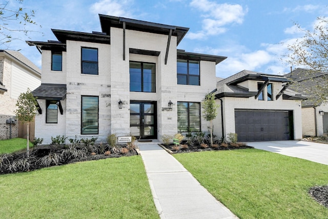 modern home with driveway, a front yard, brick siding, and a garage