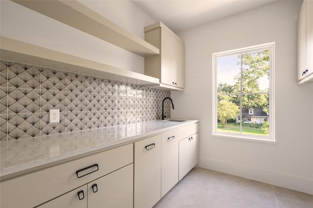 966 Lamonte Ln, Houston, TX 77018 - kitchen with open shelves, decorative backsplash, a sink, light tile patterned flooring, and light stone counters