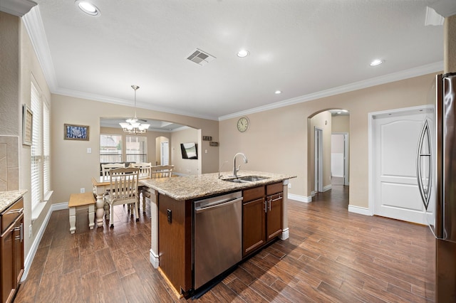 kitchen featuring a sink, stainless steel appliances, arched walkways, dark wood finished floors, and baseboards
