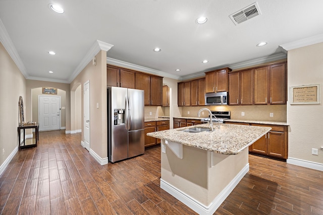 kitchen featuring appliances with stainless steel finishes, arched walkways, a sink, recessed lighting, and ornamental molding