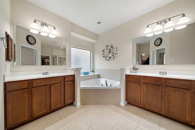 full bathroom featuring a bath, two vanities, and tile patterned floors