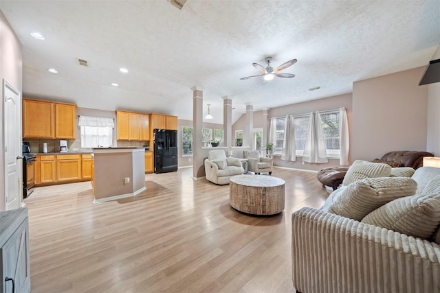 living area featuring a ceiling fan, healthy amount of natural light, light wood-style floors, recessed lighting, and a textured ceiling
