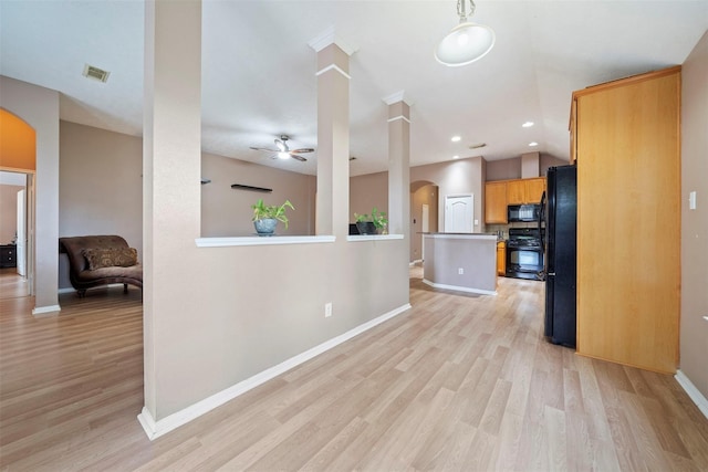 kitchen with arched walkways, black appliances, light wood-style floors, ceiling fan, and baseboards