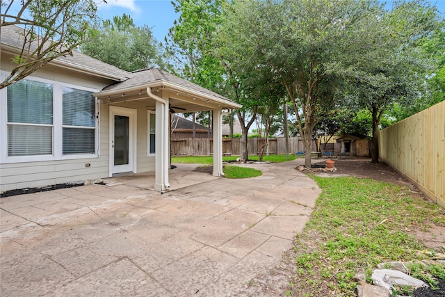 view of patio with a storage shed, a fenced backyard, and an outdoor structure