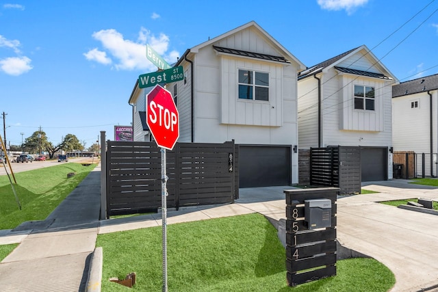 view of front of property featuring board and batten siding, concrete driveway, a garage, and a front yard