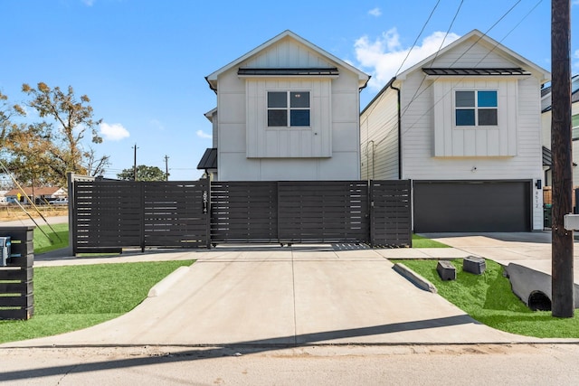 view of front facade with a garage, board and batten siding, a gate, and fence