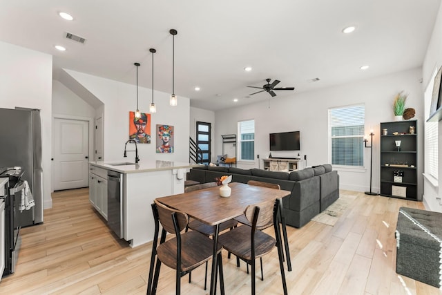 dining room with light wood finished floors, ceiling fan, recessed lighting, and stairway