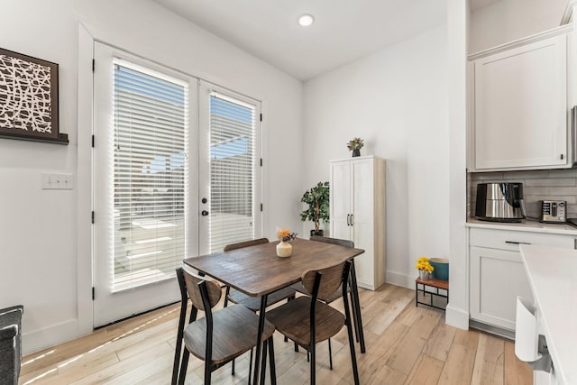 dining space featuring light wood-style flooring, french doors, recessed lighting, and baseboards