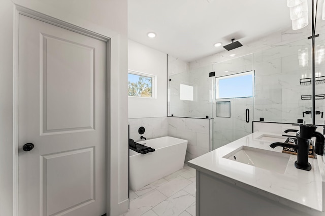 bathroom with marble finish floors, a marble finish shower, a freestanding bath, double vanity, and recessed lighting