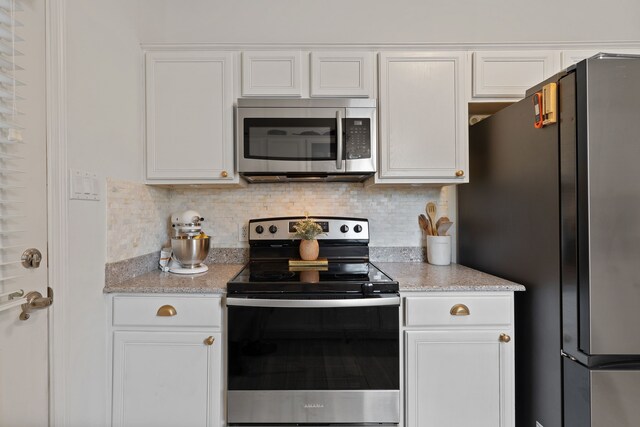 2838 Sunburst Ln, Montgomery, TX 77356 - kitchen with stainless steel appliances, white cabinets, backsplash, and light stone countertops