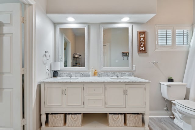 2838 Sunburst Ln, Montgomery, TX 77356 - bathroom with toilet, baseboards, double vanity, and wood finished floors