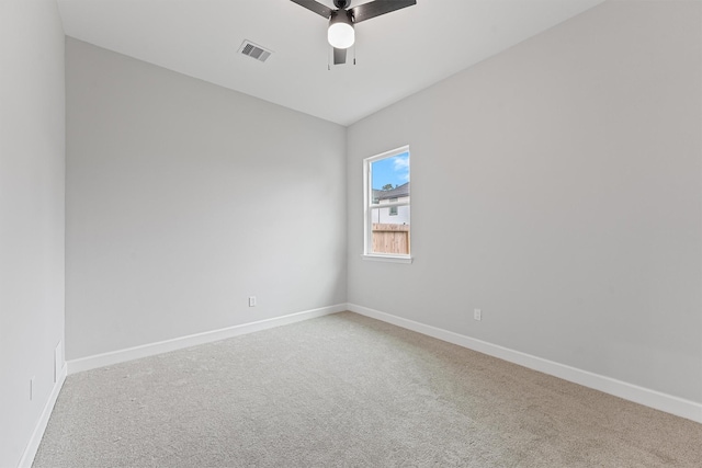 carpeted empty room with a ceiling fan and baseboards