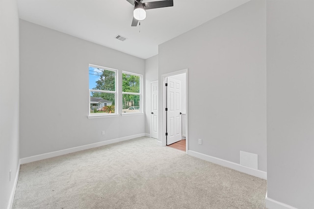 carpeted spare room with a ceiling fan and baseboards
