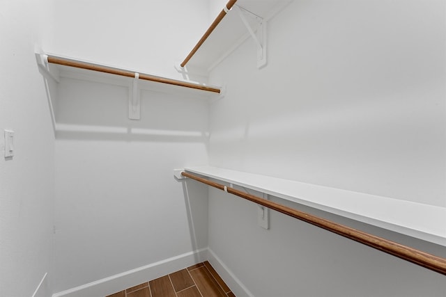 walk in closet featuring dark wood finished floors