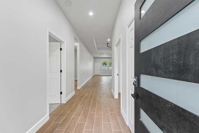 corridor with light wood-type flooring, recessed lighting, and baseboards