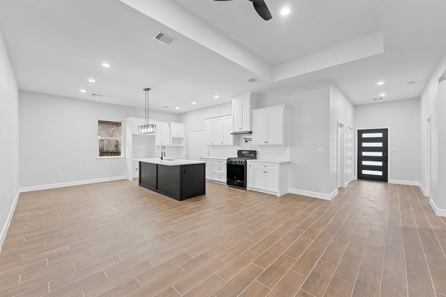 kitchen featuring black gas range oven, open floor plan, a ceiling fan, light countertops, and recessed lighting