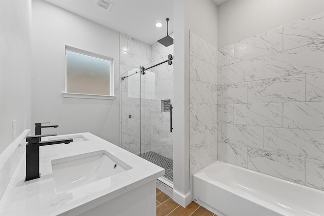 full bathroom with a sink, a marble finish shower, a tub, and recessed lighting