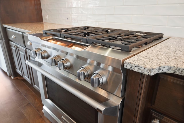 3622 Lannister Ln, Houston, TX 77055 - kitchen view of high end stainless steel range oven, decorative backsplash, dark brown cabinetry, and light stone counters