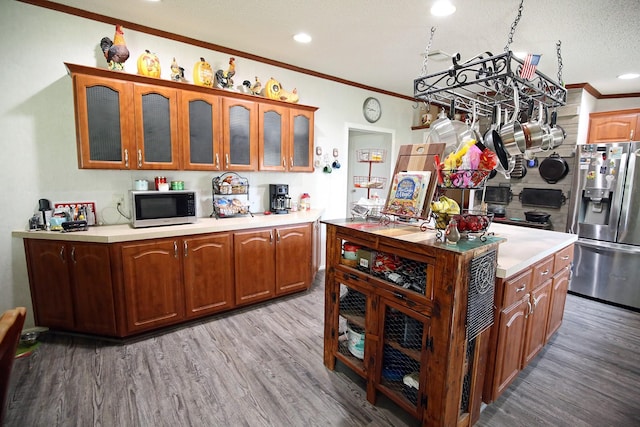 15402 Maple St, Santa Fe, TX 77517 - kitchen featuring stainless steel appliances, ornamental molding, light wood finished floors, light countertops, and glass insert cabinets