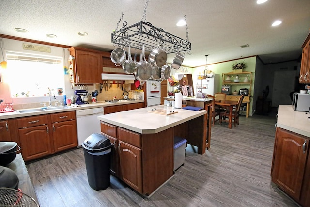 15402 Maple St, Santa Fe, TX 77517 - kitchen featuring white appliances, a sink, a kitchen island, dark wood-type flooring, and light countertops