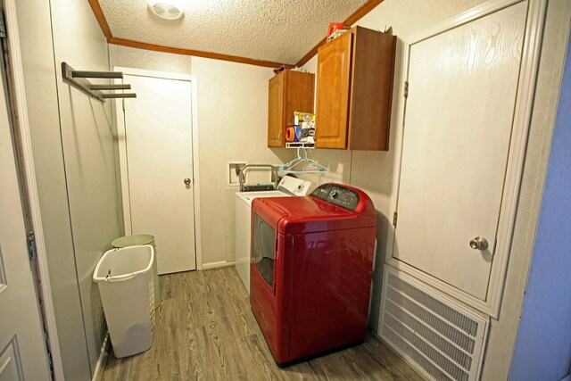 15402 Maple St, Santa Fe, TX 77517 - washroom featuring cabinet space, separate washer and dryer, wood finished floors, a textured ceiling, and ornamental molding