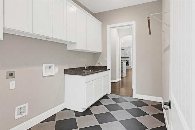 28116 Chuckwagon Trl, Magnolia, TX 77355 - laundry area with hookup for an electric dryer, cabinet space, arched walkways, baseboards, and dark floors