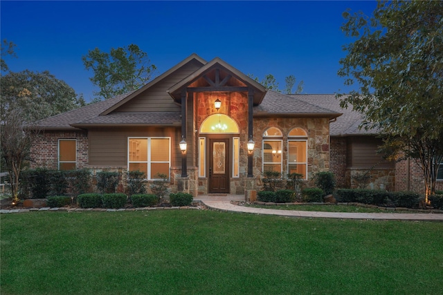28116 Chuckwagon Trl, Magnolia, TX 77355 - view of front of home featuring a front lawn, stone siding, and roof with shingles