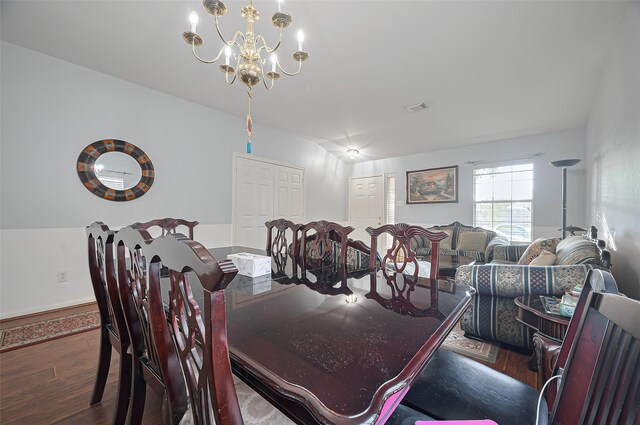 dining area featuring wood finished floors and a chandelier