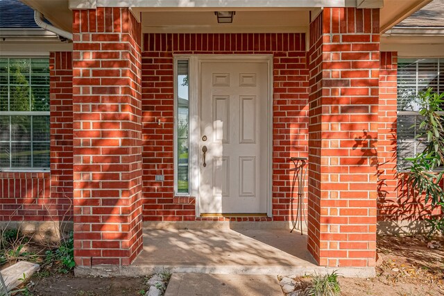 view of exterior entry with brick siding