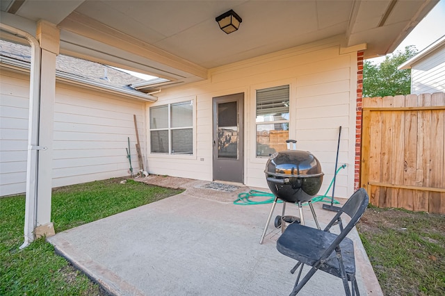 view of patio with fence and a grill