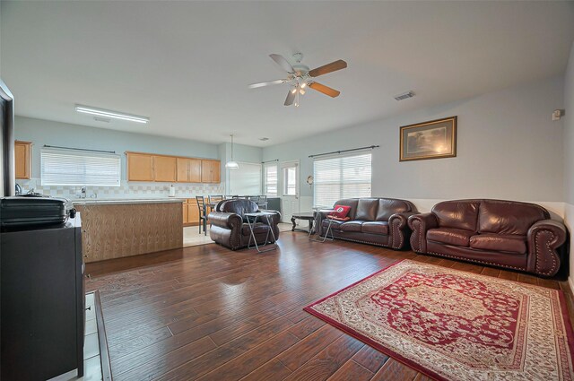 living area featuring ceiling fan and dark wood-style floors
