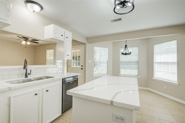 9024 Zapata Way, Willis, TX 77378 - kitchen featuring stainless steel dishwasher, a sink, a center island, light tile patterned floors, and decorative backsplash