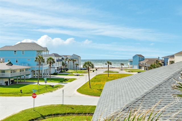 view of property's community featuring a water view, a lawn, and a residential view