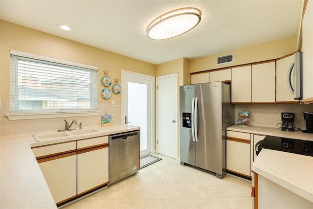 kitchen featuring appliances with stainless steel finishes, a sink, and light countertops