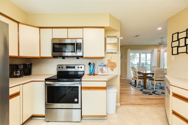 kitchen with appliances with stainless steel finishes, light countertops, ceiling fan, recessed lighting, and cream cabinetry