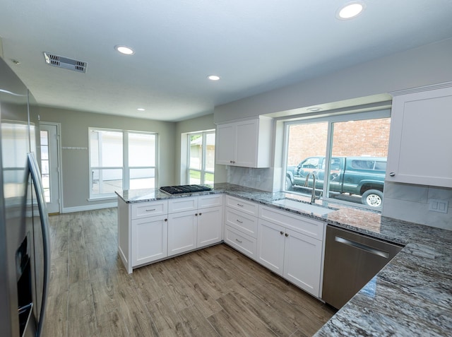 2414 Shoal Creek Dr, League City, TX 77573 - kitchen featuring stainless steel appliances, a sink, white cabinets, a peninsula, and recessed lighting