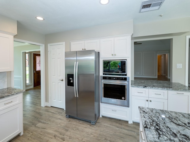2414 Shoal Creek Dr, League City, TX 77573 - kitchen with appliances with stainless steel finishes, light wood-style floors, white cabinets, recessed lighting, and light stone counters