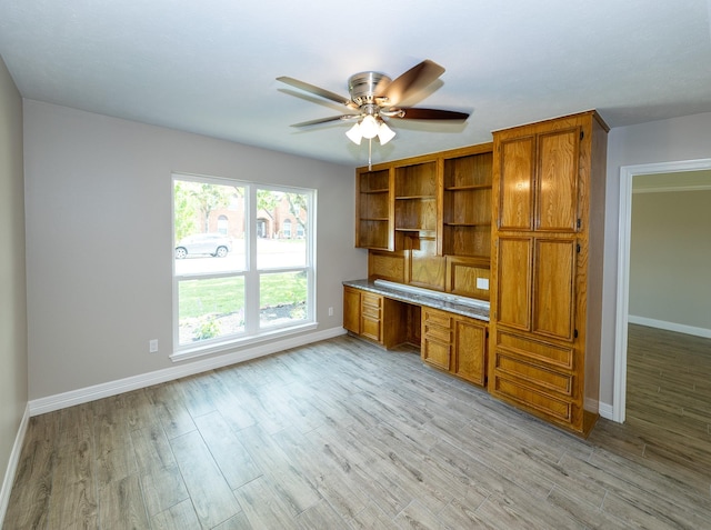 2414 Shoal Creek Dr, League City, TX 77573 - kitchen with brown cabinetry, ceiling fan, baseboards, and open shelves