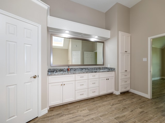 2414 Shoal Creek Dr, League City, TX 77573 - bathroom with wood finished floors, double vanity, and baseboards