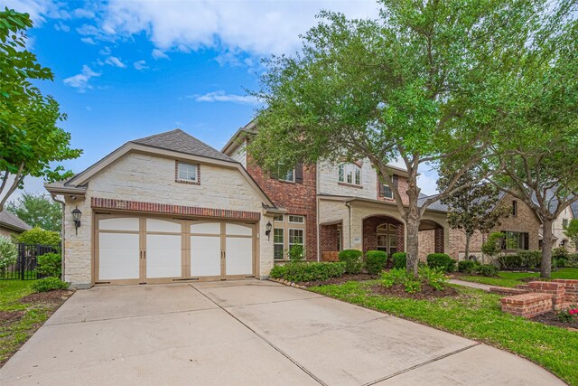 12607 Cove Landing Dr, Cypress, TX 77433 - view of front of home featuring driveway, stone siding, an attached garage, and fence
