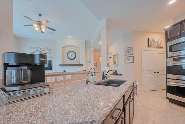 12607 Cove Landing Dr, Cypress, TX 77433 - kitchen featuring ornate columns, a sink, stainless steel appliances, light stone countertops, and a ceiling fan