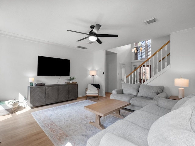 living area featuring stairway, ceiling fan, and wood finished floors